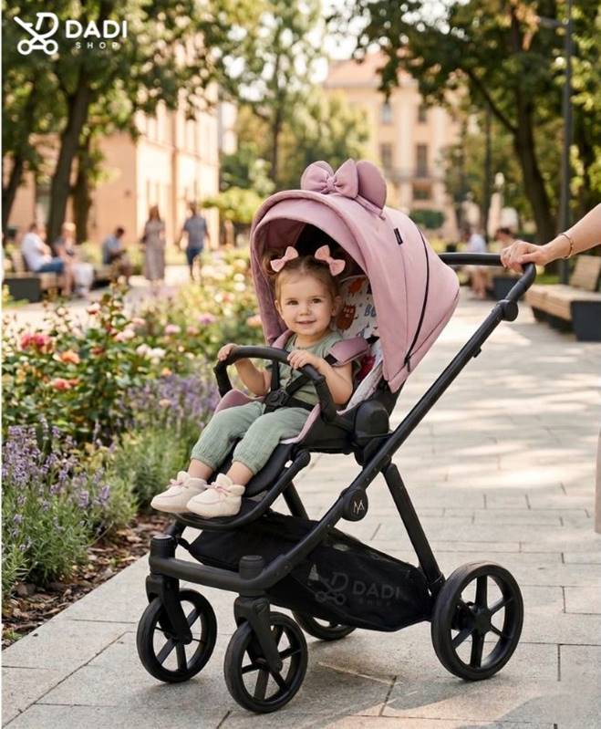 Uśmiechnięta mała dziewczynka siedząca w lekkiej spacerówce Natoni Joy New Coral Blush w parku